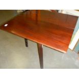 A fold over card table on square mahogany legs.