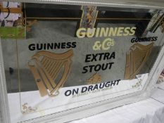 A large bevel edged mirror with Guinness advertising.