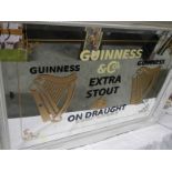 A large bevel edged mirror with Guinness advertising.