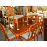 A mahogany extending dining table with 2 extra leaves and 8 dining chairs.