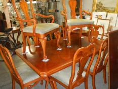 A mahogany extending dining table with 2 extra leaves and 8 dining chairs.