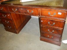 A large mahogany double pedestal desk with leather top.