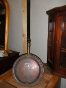 A Victorian copper warming pan.