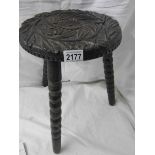 A carved stool on bobbin style legs.