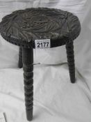 A carved stool on bobbin style legs.