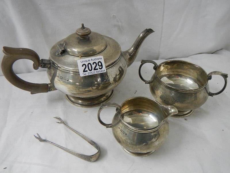 A 3 piece hall marked silver tea set and sugar nips, 684 grams.