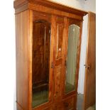 A satin walnut wardrobe with double mirrored doors.