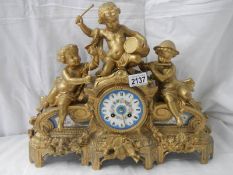 An ornate French gilt bronzed case mantel clock inset with painted porcelain panels surmounted with