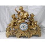 An ornate French gilt bronzed case mantel clock inset with painted porcelain panels surmounted with