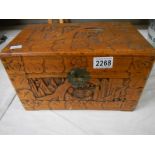 A carved camphor wood box, 12" wide, catch broken.