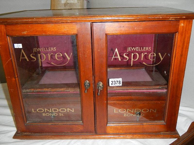A mahogany jewellery cabinet signed for Asprey's.