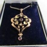 An early 20th century garnet and pearl set pendant stamped 9ct gold with attached silver chain.