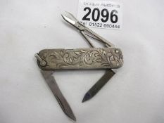 An engraved stirling silver pocket knife with 2 blades, nail file and scissors.