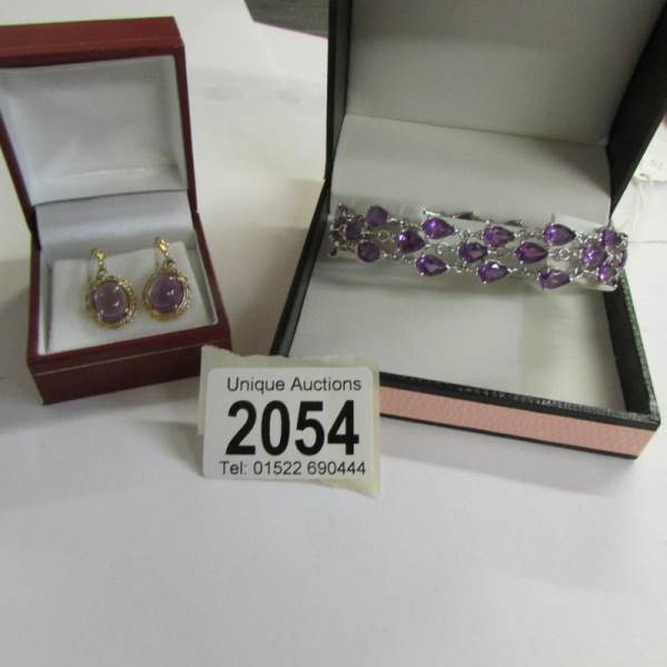 A pair of amethyst set ear pendants in yellow metal together with an amethyst set bracelet with