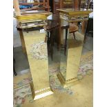 A pair of bevelled mirrored glass pedestals, 39" tall.