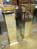 A pair of bevelled mirrored glass pedestals, 39" tall.