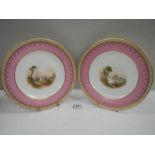 A pair of hand painted plates with gilded rims.