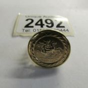 A 9ct gold ring set with St. George coin, Size M half.