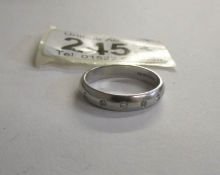 An all platinum five stone diamond band wedding ring with round cut diamonds,