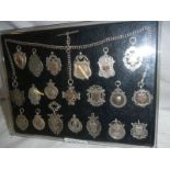A collection of 20 silver watch fobs with chain.