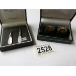 A pair of silver amber cuff links and a pair of silver pendant earrings.