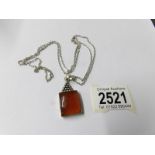 An amber pendant on silver chain,.