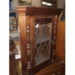 A glazed wall mounted corner cabinet