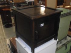 A 1930s oak commode pot cupboard with undersized enamel pot