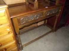 A medium oak side/hall table with 2 carved drawers