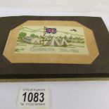 An album containing 12 WW1 silk postcards.