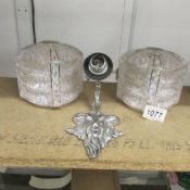 A pair of art deco lamp shades and a chromed brass rams head wall light.