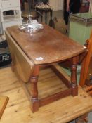 An oval drop side oak coffee table