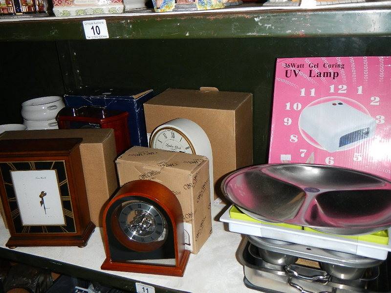 2 shelves of kitchen ware and 4 good boxed unused battery clocks.