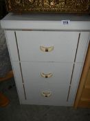 A white 3 drawer chest.