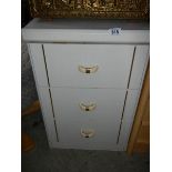 A white 3 drawer chest.