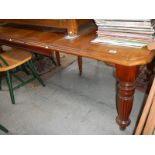 An Edwardian mahogany extending dining table.