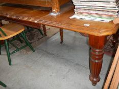 An Edwardian mahogany extending dining table.