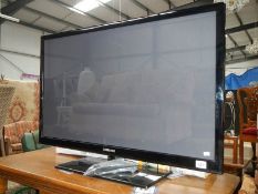 A Samsung flat screen television with remote control.