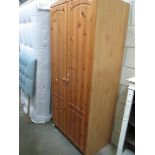 A modern pine wardrobe (base facia panel needs re-fixing)