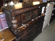 A dark oak buffet cupboard with leaded glass doors