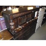 A dark oak buffet cupboard with leaded glass doors