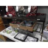 An antique brass effect coffee table with magazine rack base and smoked glass top