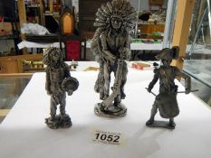 Two metal figures of American Indians and a soldier.