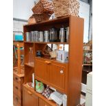 A teak cabinet with contents.