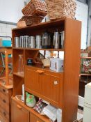 A teak cabinet with contents.