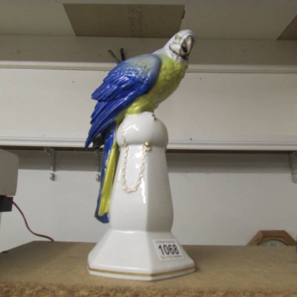An art deco Katsutte German porcelain parrot on a stand, circa 1930's, impressed mark cat in house.