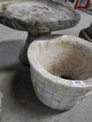 A concrete bird bath and planter.