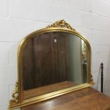 A gilded arched top overmantel mirror in good condition.
