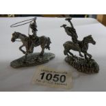 A white metal cowboy on horse with lasso together with a white metal American Indian on horse,