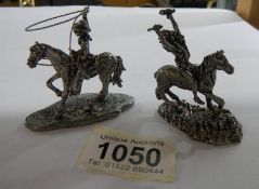 A white metal cowboy on horse with lasso together with a white metal American Indian on horse,